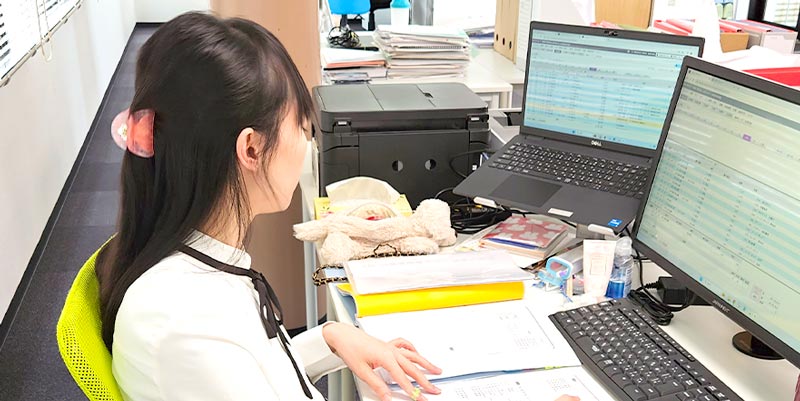 事務所で女性スタッフが仕事をする風景