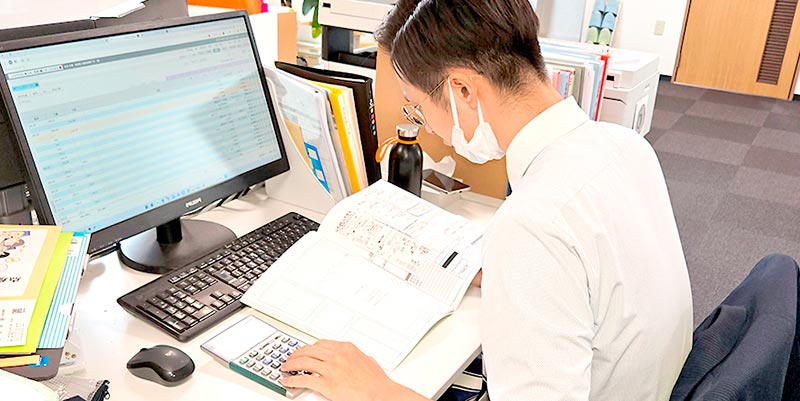 事務所で男性スタッフが仕事をする風景